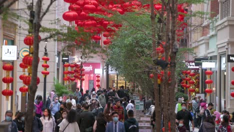 Fußgänger-Und-Käufer-Gehen-An-Dekorativen-Chinesischen-Laternen-Vorbei,-Die-Von-Der-Decke-Hängen,-Um-Das-Chinesische-Neujahrsfest-In-Einer-Einkaufsstraße-In-Hongkong-Zu-Feiern