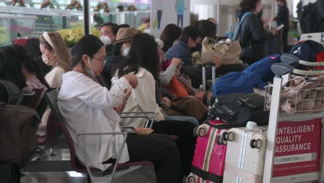 Passagiere-Und-Chinesische-Touristen-Sitzen-In-Der-Abflughalle-Des-Internationalen-Flughafens-Chek-Lap-Kok-In-Hongkong