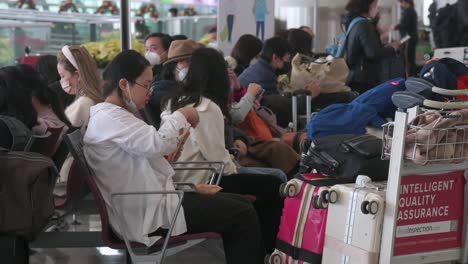 Pasajeros-Y-Turistas-Chinos-Se-Sientan-En-La-Sala-De-Salidas-Del-Aeropuerto-Internacional-Chek-Lap-Kok-De-Hong-Kong