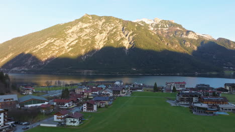 Pueblo-De-Pertisau-En-La-Orilla-Del-Hermoso-Lago-Achensee-Durante-La-Puesta-De-Sol-En-Tirol,-Austria---Toma-Aérea-De-Drones