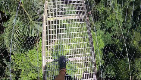 Walking-across-a-suspension-bridge-in-the-cloud-forest-of-Monte-Verde,-Costa-Rica