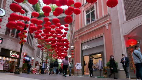Chinesische-Fußgänger-Und-Käufer-Gehen-An-Dekorativen-Chinesischen-Laternen-Vorbei,-Die-Von-Der-Decke-Hängen,-Um-Das-Chinesische-Mondneujahrsfest-In-Einer-Einkaufsstraße-In-Hongkong-Zu-Feiern