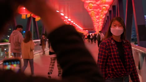 Ein-Mädchen-Posiert-Für-Ein-Foto-An-Einer-Fußgängerbrücke,-Die-Mit-Chinesischen-Roten-Laternen-Geschmückt-Ist,-Die-Von-Der-Decke-Hängen,-Um-Das-Chinesische-Neujahrsfest-In-Hongkong-Zu-Feiern
