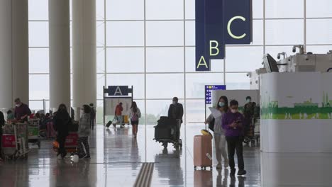 Se-Ve-A-Los-Pasajeros-Y-Viajeros-Caminando-Por-La-Sala-De-Facturación-Y-Salida-De-La-Aerolínea-En-El-Aeropuerto-Internacional-Chek-Lap-Kok-De-Hong-Kong.