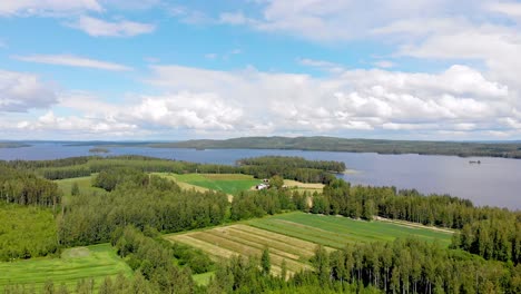 Aerial-view-of-farmland-with-a-lake-and-islands-in-the-background-on-a-sunny-summer-day