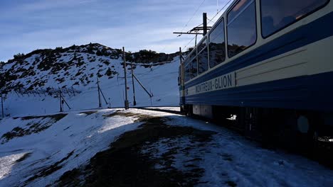 Mountain-cog-railway-train-carriage-leaving-the-summit-stop-in-winter