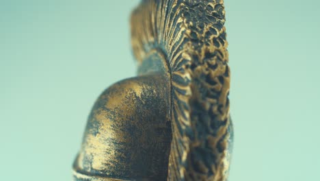 A-rotating-close-up-macro-shot-of-a-spartan-warrior-metal-bronze-ancient-greek-helmet,-studio-lighting,-slow-motion,-4K-video