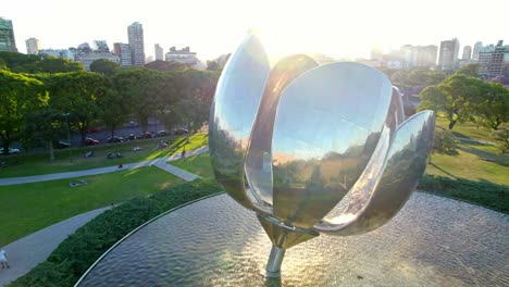 Aerial-orbit-near-the-petals-of-the-Floralis-Generica-in-the-Recoleta-neighborhood-with-the-sun-in-the-background,-epic-drone-shot