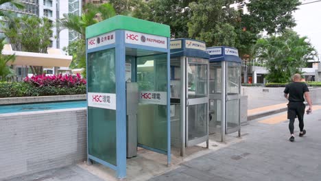 Chinesische-Fußgänger-Gehen-An-öffentlichen-Telefonzellen,-Auch-Payphones-Genannt,-Vorbei,-Da-Sie-Im-Zeitalter-Von-Smartphones-Und-Internet-Schnell-Aussterben-Und-Verschwinden