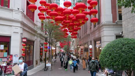 Chinesische-Fußgänger-Und-Käufer-Gehen-An-Dekorativen-Chinesischen-Laternen-Vorbei,-Die-Von-Der-Decke-Hängen,-Um-Das-Chinesische-Mondneujahrsfest-In-Einer-Einkaufsstraße-In-Hongkong-Zu-Feiern