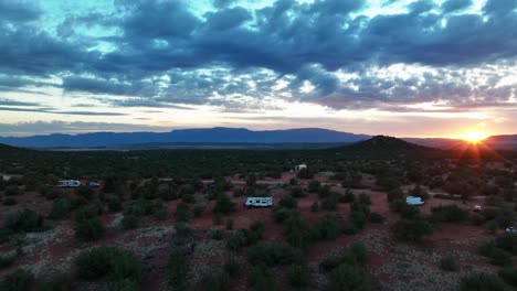 Desert-Landscape-With-Campervans-In-Sedona,-Arizona-At-Sunset---aerial-pullback