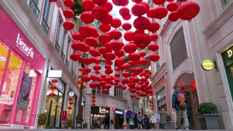 Chinesische-Fußgänger-Gehen-An-Dekorativen-Chinesischen-Laternen-Vorbei,-Die-Von-Der-Decke-Hängen,-Um-Das-Chinesische-Neujahrsfest-In-Einer-Einkaufsstraße-In-Hong-Kong-Zu-Feiern