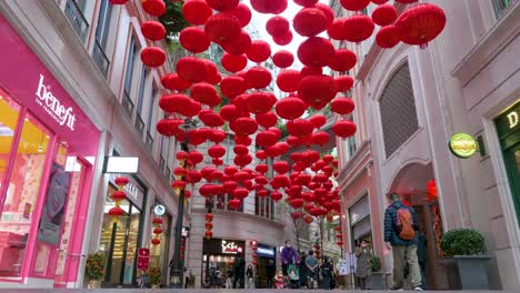 Peatones-Chinos-Pasan-Junto-A-Farolillos-Chinos-Decorativos-Que-Cuelgan-Del-Techo-Para-Celebrar-El-Festival-Del-Año-Nuevo-Lunar-Chino-En-Una-Calle-Comercial-De-Hong-Kong