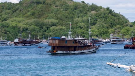 Beautiful-liveaboard-tourist-boat-ship-cruise-moving-though-blue-ocean-with-tropical-islands-in-Labuan-Bajo,-Flores-Island-in-Indonesia