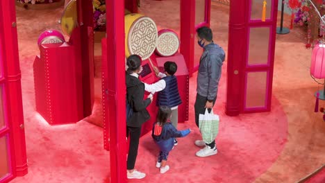 A-boy-plays-a-traditional-drum-as-a-family-visit-a-Chinese-New-Year-theme-installation-event-for-the-Chinese-Lunar-New-Year-in-Hong-Kong