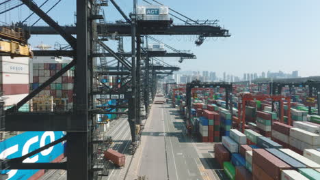 Low-flyover-of-ACT-container-port-terminal-in-Hong-Kong-with-container-loading-operations-at-daytime