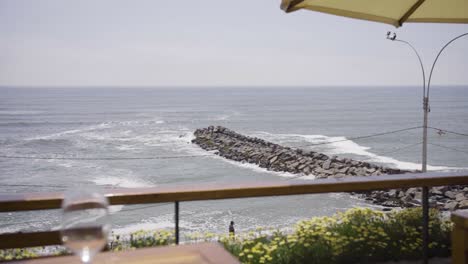 Slow-Motion-Shot-Of-Calm-Seascape-From-Resort's-Restaurant-Table,-Peru