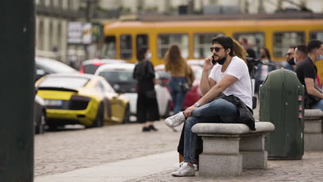 Hombre-De-Mediana-Edad-Sentado-En-Un-Banco-De-Piedra-Hablando-Por-Teléfono