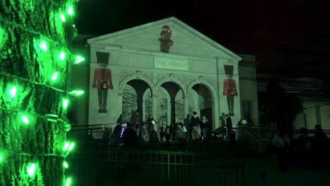 Lindo-Oso-De-Peluche-Bailando-En-El-Edificio-Mientras-La-Gente-Visita-La-Exhibición-Del-Zoológico-En-El-Festival-De-Navidad