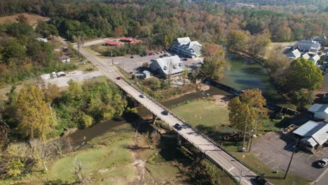 Aerial-over-bridge-crossing-over-creek-and-waterfalls-in-Old-Town-Helena,-Alabama