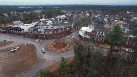 Aerial-pull-away-of-small-town-shops-and-roundabout-in-front-of-suburban-area-at-Moss-Rock-Preserve-in-Hoover,-Alabama
