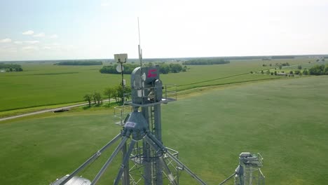 Luftaufnahme-Umlaufende-Wettermessgeräte-Und-Fernmeldeturmantenne-Mit-Blick-Auf-Das-Ländliche-Indiana-Ackerland