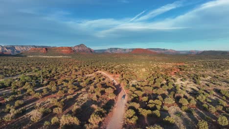 Vehicle-Driving-On-Road-In-Desert-Landscape-Of-Sedona-In-Arizona---aerial-drone-shot