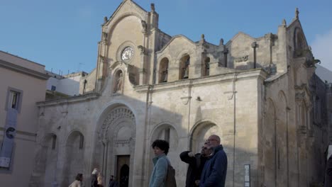 Pequeña-Iglesia-En-Matera-Italia-Con-Gente-Al-Frente-Y-Video-De-Enfoque-En-Rack