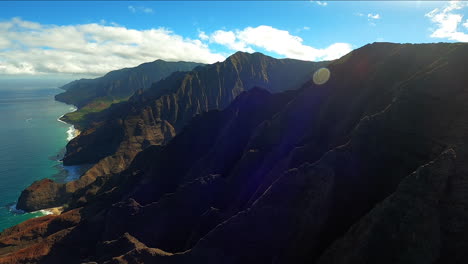 Vista-Aérea-De-La-Costa-Azul-A-Lo-Largo-De-Colinas-Con-Luz-Solar-En-Kauai-Hawaii