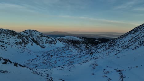 Drone-shot-from-Musala-peak-during-sunrise,-in-the-distance-you-see-Vitosha-mountain-and-foggy-Sofia,-Bulgaria,-highest-summit-on-the-Balkans,-shelter,-golden-hour,-blue-hour,-dawn