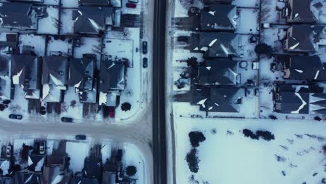 Winter-sunrise-drone-footage-of-a-community-in-Calgary-with-snow-covered-houses-and-streets