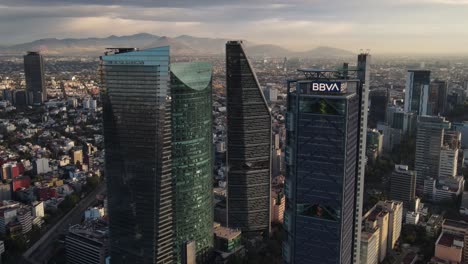 Vista-Aérea-De-Las-Torres-De-La-Ciudad-De-México-En-La-Avenida-Reforma-Al-Amanecer-Y-El-Horizonte-Del-Paisaje-Urbano,-Toma-Cinematográfica-De-Drones