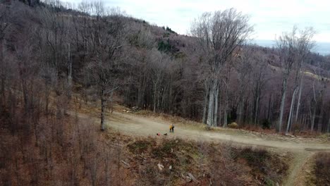 2-people-standing-on-the-edge-of-the-mountain-aerial-zoom-out-of-the-mountains-in-Sljeme,-Croatia