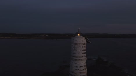 Aerial-drone-circling-around-Lighthouse-at-dusk,-dolly-out-reveal-dusk-sky