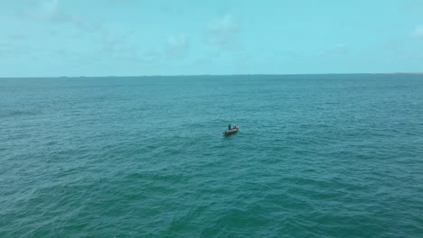 Victoria-Island-Lagos,-Nigeria---20-November-2022:-Drone-view-of-a-fisherman-on-a-fishing-boat-on-the-coastline-of-Lagos