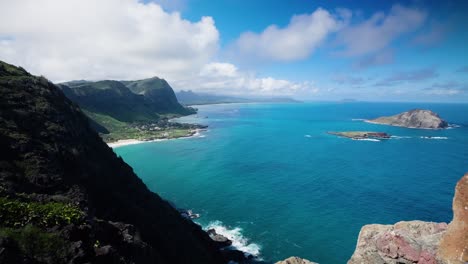 Timelapse-of-Oahu,-Hawaii-shoreline-high-up-from-peak-of-Makapuu-Point-Lighthouse-Trail-on-a-bright-blue-day-with-beautiful-whispy-white-clouds-passing-by