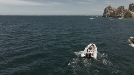 Dinghy-tourist-boat-braving-the-waves-at-Cabo-San-Lucas-resort-city-aerial