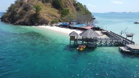 Aerial-View,-People-in-Boat-Arriving-on-Pier-of-Exotic-Komodo-Island,-Indonesia