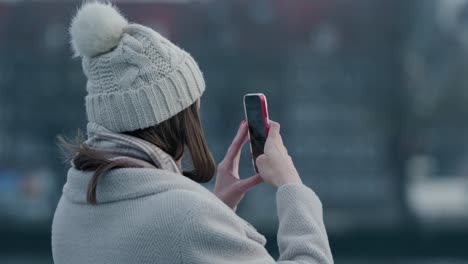 Mädchen,-Das-Winterkleidung-Trägt-Und-Mit-Ihrem-Handy-Auf-Der-Straße-Fotografiert