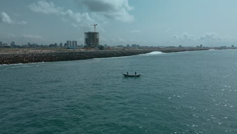 Victoria-Island-Lagos,-Nigeria---20-November-2022:-Drone-view-of-a-fisherman-on-a-fishing-boat-on-the-coastline-of-Lagos