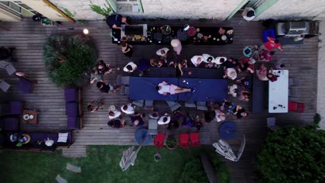 Rising-shot-of-a-man-lying-on-top-of-a-table-with-colleagues-lifting-their-arms-to-the-sky