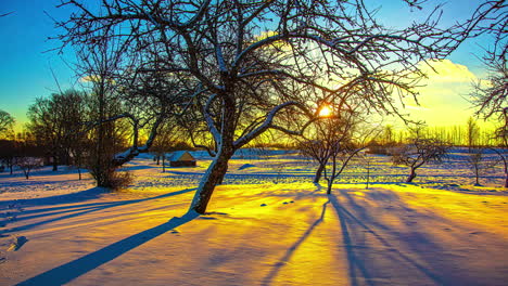 Golden-sunrise-in-a-winter-landscape-with-a-cabin---dynamic-sliding,-panning-time-lapse
