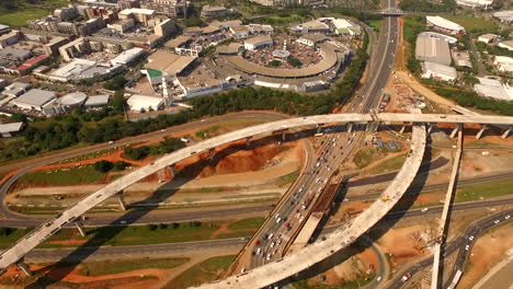 Drone-Aéreo-Sobre-Un-Gran-Sitio-De-Construcción-En-Una-Carretera-Para-Revelar-El-Centro-De-Envío-De-Puerta-De-Enlace-Y-El-Océano-índico