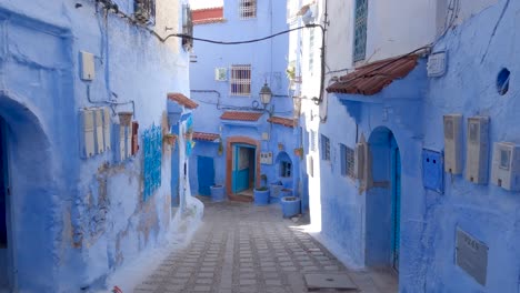 POV-Walking-Down-Empty-Street-With-Blue-Painted-Buildings-In-Chefchaouen,-Morocco