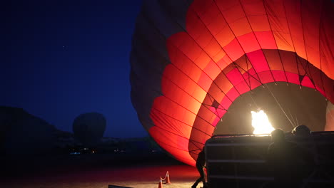 Vorbereitung-Von-Heißluftballons-Für-Den-Flug-über-Kappadokien-Türkei-Im-Morgengrauen,-Brennerflammen,-Fallschirm-Und-Menschen
