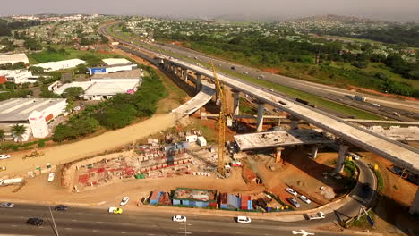 Aerial-drone-rise-over-construction-at-a-busy-highway-interchange