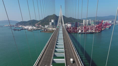 Rising-Aerial-Shot-Over-Stonecutters-Suspension-Bridge-in-Hong-Kong-on-a-Sunny-Day