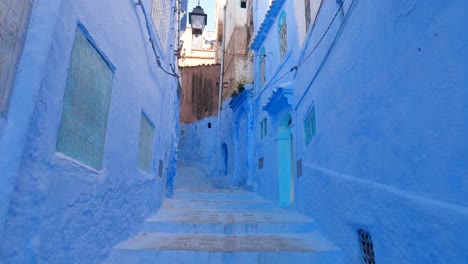 Slow-Tilt-Down-View-Along-Empty-Iconic-Blue-Painted-Street-In-Chefchaouen