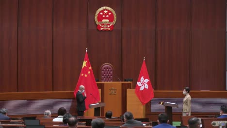 Former-Hong-Kong-Chief-Executive-Carrie-Lam-presides-over-the-oath-taking-ceremony-as-she-stands-next-to-the-People's-Republic-of-China-and-Hong-Kong-flags-at-the-Legislative-Council-main-chamber