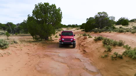 Jeep-Wrangler-Rojo-Conduciendo-Fuera-De-La-Carretera-En-El-Desierto-De-Utah,-Ee.uu.---Toma-Aérea-De-Drones